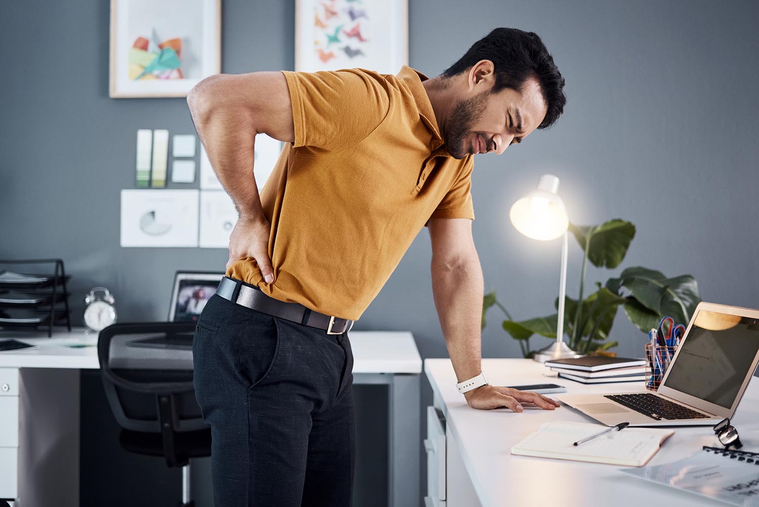 Night, back pain and business man with stress at office desk in